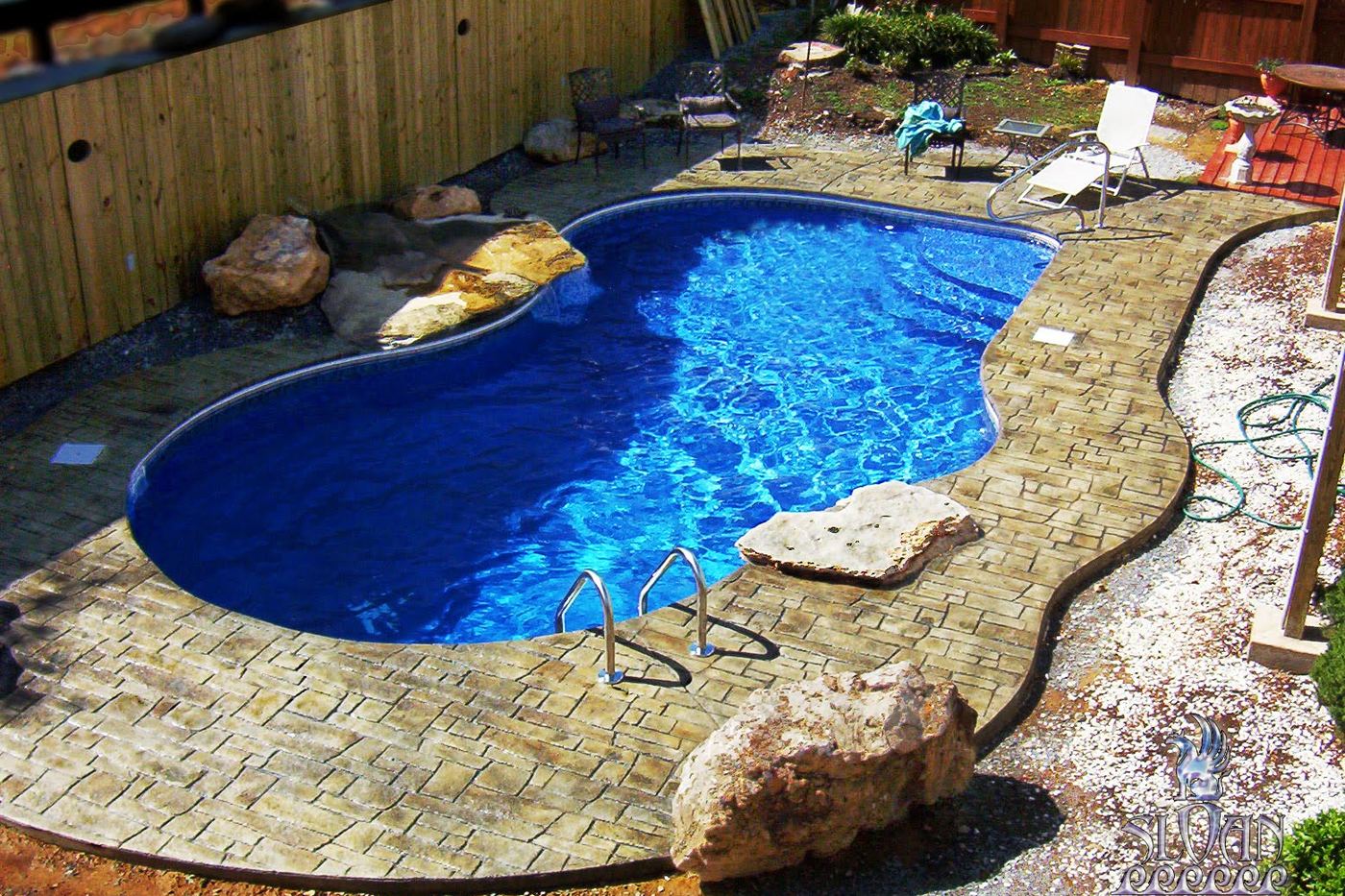 a textured deck around a freeform pool with stone accents